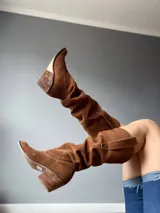Botas de cuero color marrón, de caña alta y estilo cowboy.