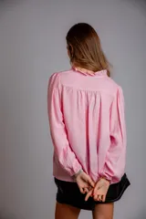 Camisa celeste con volados en cuello y en la parte delantera, con cordones.