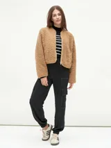 Campera negra de tela tipo sherpa con cierre frontal y cuello redondo.