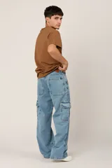 Pantalón de jean celeste, corte holgado, con bolsillos cargo laterales y costuras frontales.