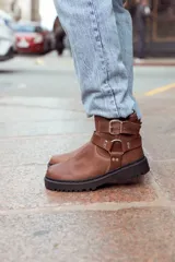 Botas de cuero color marrón con suela track y hebillas decorativas.