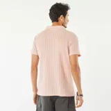 Remera color rosa de punto gofrado con cuello polo y mangas cortas.