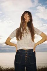 Top de punto con estampado floral en tonos rosa, gris y blanco. Tiene cuello redondo, mangas cortas y terminaciones acanaladas.