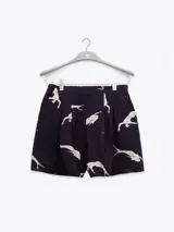 Short negro con estampado de aves blancas, cintura elastizada, pliegues al frente y bolsillos laterales.