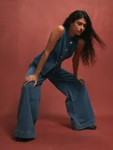 Chaleco de jean azul con botones y bolsillos frontales.