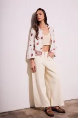 Blusa blanca con estampado de cachemir en color marrón y bordado floral en el ruedo y mangas acampanadas.