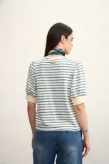 Remera de manga corta con cuello redondo y estampado de rayas horizontales blancas y negras. Mangas abullonadas con puño blanco.