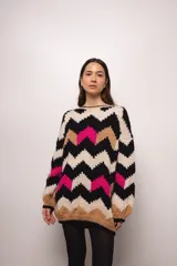 Buzo tejido a mano con lana merino, estilo oversized con diseño de ondas en colores blanco, negro, azul y marrón.