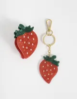 Set de accesorios para el pelo que incluye un broche de pelo con forma de fresa y un llavero con espejo con forma de fresa.