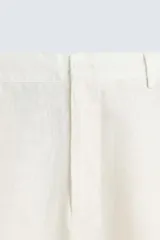 Pantalón de lino color blanco, de corte regular fit. Presenta cintura elástica, bolsillos frontales y traseros de plastrón, con cierre frontal de cremallera y botón.