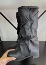 Botas bucaneras negras de cuero vegano, con caña alta arrugada y cordones cruzados ajustables.