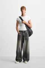 Pantalón de jean negro de corte amplio, con cinco bolsillos, efecto lavado y cierre frontal con cremallera y botón.
