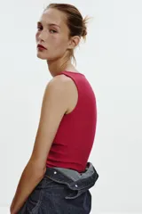 Camiseta sin mangas color fucsia, de corte ajustado y cuello barco.