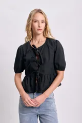 Blusa negra con escote redondo y mangas cortas abullonadas. Presenta lazos frontales para ajustar el escote y un corte con frunce en la cintura.