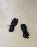 Sandalias de cuero marrón con plataforma y tira ancha sobre los dedos.