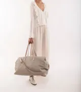 Bolso de viaje tipo weekender de cuero color marrón con doble asa de mano y correa bandolera ajustable y desmontable.