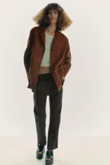 Blazer de cuero color marrón, con cuello solapa de muescas y manga larga. Tiene bolsillos con solapa en delantero, forro interior y cierre frontal con botones.