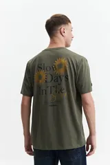 Remera verde militar de manga corta con estampado de soles y texto en la espalda.