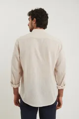 Camisa de lino color beige, de cuello mao y manga larga.