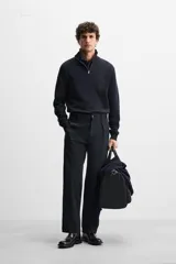 Jersey negro de punto de algodón, corte recto, cuello perkins con cremallera metálica y mangas largas terminadas en rib.