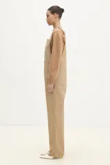 Mono enterizo negro de corte recto, con cintura normal con cierre de botón, pierna recta de largo completo, dos bolsillos laterales oblicuos, dos bolsillos deslizantes en la parte inferior y bolsillo tipo canguro en la parte delantera.