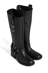 Bota de cuero negra de caña alta con hebillas y apliques metálicos.