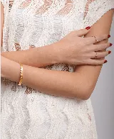 Pulsera dorada de acero con diseño martillado y medida ajustable.