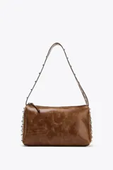 Bolso de hombro marrón con apliques metálicos plateados en los laterales y en la correa. Cierre con cremallera.