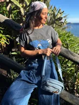 Remera gris con estampa de águila azul y texto 'Powerful Woman' en dorado.