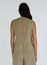 Chaleco beige de lino con escote en V, cierre frontal con botones y terminaciones desflecadas.