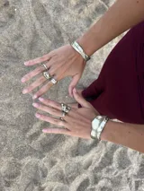 Brazalete rígido plateado con textura irregular.