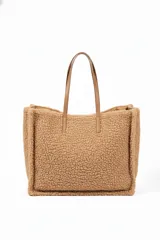 Cartera tipo tote bag color rosado, con textura de borrego y asas de cuero sintético en tono nude.