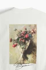 Remera blanca de corte holgado con estampado de texto en cursiva color negro en el centro del pecho.