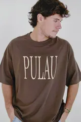 Remera verde con estampado de la palabra "Pulau" en color lila.
