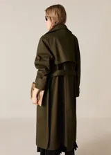Trench coat verde militar con cuello solapa ancho, doble botonadura, cinturón desmontable, trabillas en cintura y puños, dos bolsillos laterales y forro interior.