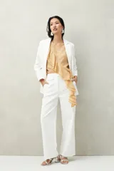 Top blanco de tencel sin mangas, de corte asimétrico, con volados en diagonal.