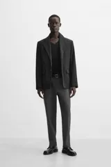 Pantalón slim fit negro confeccionado en tejido con elasticidad en ambas direcciones. Cuenta con bolsillos frontales y traseros de vivo con botón. Cierre frontal con cremallera y botón.