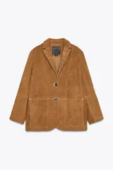 Blazer de cuero color marrón, con cuello solapa de muescas y manga larga. Bolsillos delanteros ocultos en costura y cierre frontal con botones.