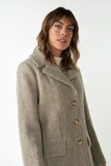 Tapado marrón de lana con cuello con solapa, manga larga, forrado, con bolsillos y cierre frontal con botones.