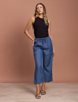 Pantalón capri de jean azul oscuro, con cintura elastizada con cordón ajustable y bolsillos laterales.