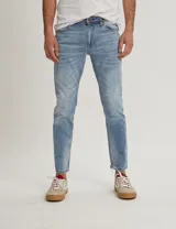 Jean de corte slim en denim azul claro con efecto desgastado.