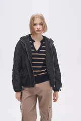 Campera negra de manga larga con capucha, cierre frontal con botones a presión, bolsillos laterales y cordón ajustable en la cintura.