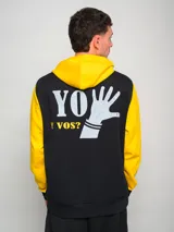 Hoodie negro con mangas amarillas y escudo bordado en el pecho.