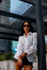 Camisa color beige con bordado inglés, de corte recto, manga larga abullonada con puño y cuello camisero.