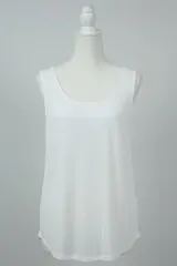 Musculosa blanca de algodón, de corte amplio y cuello redondo. Ideal para uso diario.