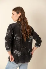 Camisa negra con bordados de motivos celestiales, de seda con botones forrados.