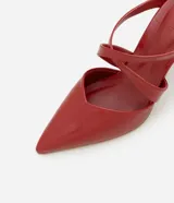 Zapato mule color rojo charol con punta fina y tiras cruzadas sobre el pie. Tacón fino de 8,5 cm de altura.