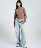 Saco de punto color marrón topo, de manga larga y corte cropped, con cuello alto y cierre frontal completo con cremallera. Presenta puños y bajo acanalados.