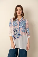 Túnica azul con bordados florales, cuello camisero y botones forrados.
