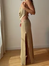 Falda larga tejida color vino tinto con brillo dorado, de corte ajustado y abertura lateral en la pierna.